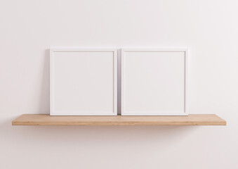 Two Interior frame mockups with square white frame on oak wooden shelf and white wall background. 3D rendering.