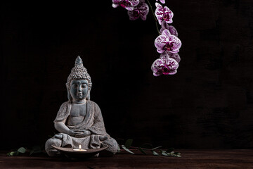 Close up of a statue of Buddha with singing bowl and prayer beads (mala) for chanting mantras as decoration on an old wooden board - yoga