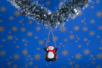 Creative layout,Christmas decorations,a penguin on a swing with starry sky background