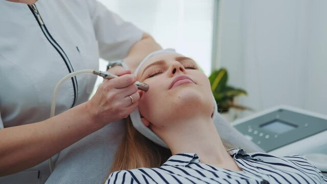 Close up of young woman getting vacuum microdermabrasion. Peeling treatment at cosmetic beauty spa clinic.