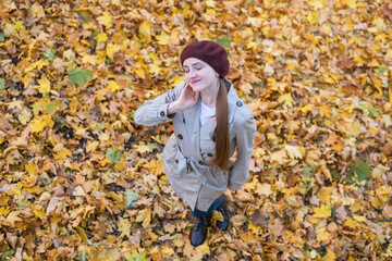 Pretty young woman enjoying good weather in autumn forest. Top view.