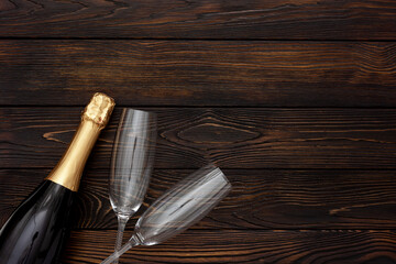 Fototapeta na wymiar Champagne as New Year symbol on dark wooden background top view