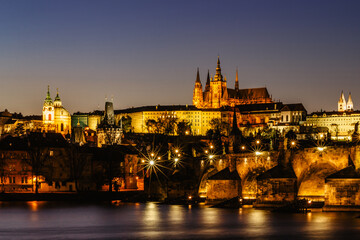Obraz premium Postcard view of night Prague panorama, capital of the Czech republic.Amazing European cityscape.Prague Castle,Charles Bridge,Vltava river at colorful sunset.Famous tourist destination.Night city.
