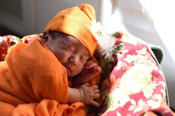 Newborn baby in orange colors - Holiday seasons theme
