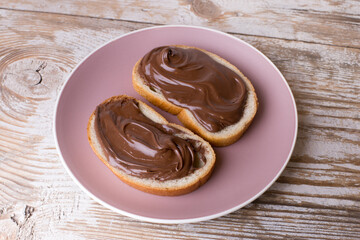 Chocolate-nut cream spread on slices of bread. Delicious Breakfast with chocolate and nut paste.
