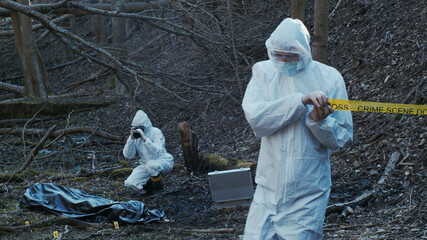 Detectives are collecting evidence in a crime scene. Forensic specialists are making expertise....