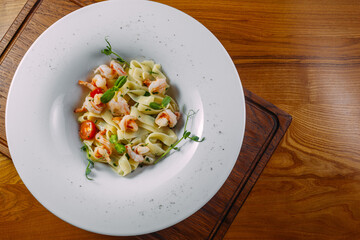 pasta with seafood in a white plate on a wooden table