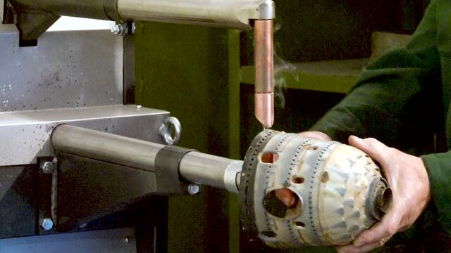 Spot welding of casing of combustion chamber of  aircraft jet engine. Sparks fly apart in spot welding process. Repair of aircraft gas turbine engines in factory. Aviation.
