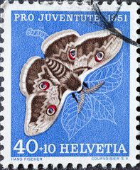 Switzerland - Circa 1951 : a postage stamp printed in the swiss showing a Viennese night peacock butterfly (Saturnia pyri) on a pear leaf