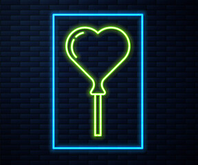 Glowing neon line Balloons in form of heart with ribbon icon isolated on brick wall background. Vector.