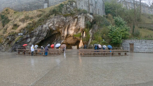 Lourdes / France - March 12, 2020: The Grotto of Massabielle is the place where the Virgin appeared to Bernadette Soubirous, a 14-year-old girl, in 1858. At the back left of the Grotto is the Spring.