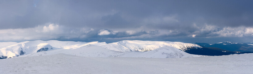 Fototapeta na wymiar A panorama of a snow-covered mountain range. Panorama from multiple shots.