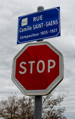 Carcassonne / France - March 15, 2020: French traffic sign, STOP sign and Carcassonne street sign Rue Camille Saint-Saens Street.