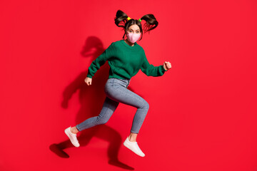 Fototapeta na wymiar Profile side photo of trendy stylish brunette tails lady wear jeans green pullover jeans mask jump run isolated on red color background