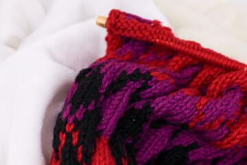 Close up red knitted wool sweater on white fur background