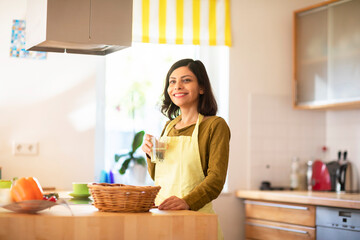 Frau mit langen schwarzen Haaren arbeitet in der Küche 