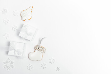 Arrangement of white Xmas Decorations: snowflakes, DIY gifts and gingerbread on white. Top view, flat lay, copy space.