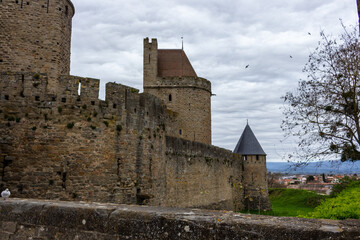 Fototapeta na wymiar Tresau Tower and vestiges of the Gallo-Roman ramparts on the Medieval City of Carcassonne, France. The Tresau Tower (meaning “treasure”) completes the defences of the Narbonne Gate.