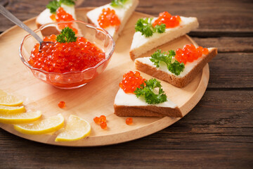 toast with red caviar on  wooden tray