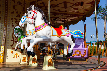 Fototapeta na wymiar Carousel horse in Children park. Carousel ride with horses.