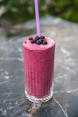 Glass of blueberry milkshake cocktail or smoothie.