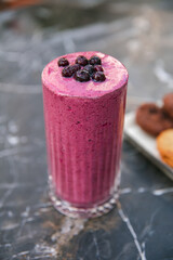 Glass of blueberry milkshake cocktail or smoothie.