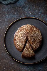 Homemade dark chocolate cake with shredded almond and desiccated coconut topping