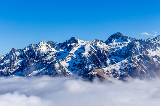 Snow and mountain peaks in the french Pyrenees near the Luchon Superbagn&egrave;res Ski Resort in the Arrondissement of Saint-Gaudens, Occitania, Haute-Garonne, France. The Luchonnais Mountains aerial view.
