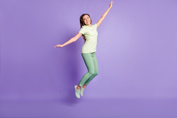 Fototapeta na wymiar Full body photo of charming person jump arms flying wear light green outfit isolated on violet color background