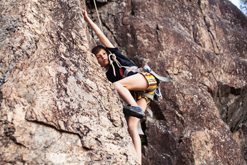 cute teen kid climbing on rock with insurance, lifestyle sport people concept