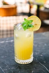 Glass of cold lemonade beverage. Summer refreshing drink with lemon and mint.