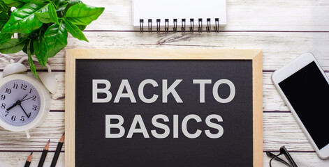 BACK TO BASICS written on a black background near pencils, a smartphone, a white notepad and a...