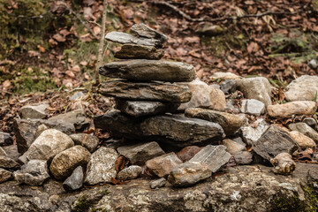 Balanced cairn or troll stoned pyramid, tourist memory sign or hiking path marking at the Valley Val d’Astau, southwest of Bagneres de Luchon in the French Pyrenees. The trail to Lake d'Oô, France.