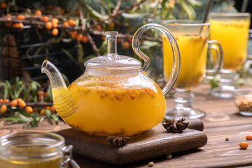 Beautiful glass teapot with sea buckthorn tea. Hot winter drinks