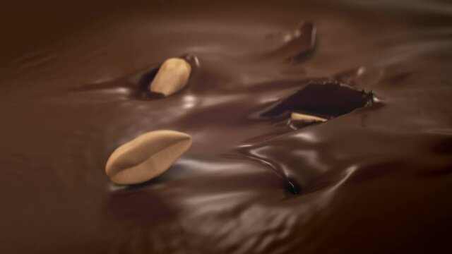 Peanuts Splashing Into Liquid Milk Chocolate in 4K Super slow motion