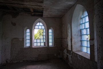 Inside abandoned house. View on broken window with curtain. Grunge scene