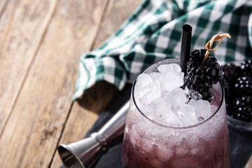 Fresh blackberry cocktail in cold glass on wooden table.Copy space