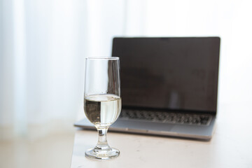 パソコンの前で飲み物を飲む。家でリモート・オンライン飲み、おうち時間。