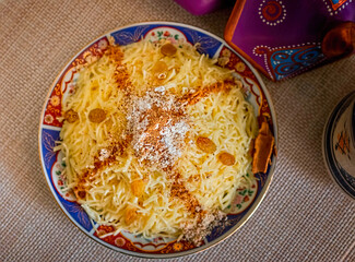 Moroccan Seffa with Angel Hair Pasta Sweetened with Sugar, Cinnamon and Almonds, presented on Traditional Decorated Dishes.