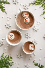 Christmas hot chocolate with snowman marshmallows on a white background top view.  