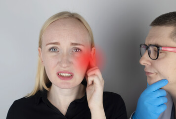 A woman suffers from pain in the ear. The auditory meatus hurts due to otitis media, cerumen plug,...