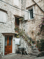 old stone house yard with stairs with flora plants flowers under the white wooden window shutters sea lifestyle hipster