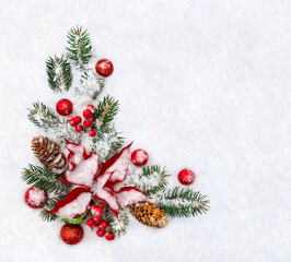 Christmas decoration. Branches christmas tree, flower of red poinsettia, brown natural spruce cones, red ball, red berries on snow with space for text. Top view, flat lay