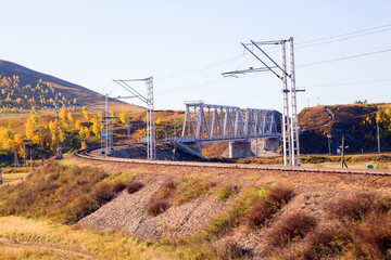 Railway bridge on the background of autumn nature. Horizontally.