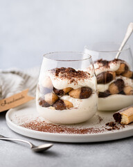 tiramisu dessert in a glass on a light background