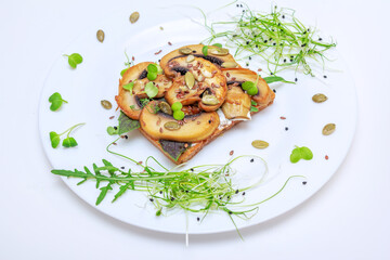 Sandwich with fried mushrooms, basil, pumpkin seeds and microgreens - radish and onion sprouts, served on white plate