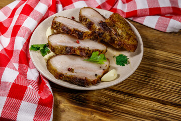 Baked pork belly in a plate on wooden table