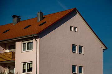 Fototapeta na wymiar Apartment house with blue sky and red roof