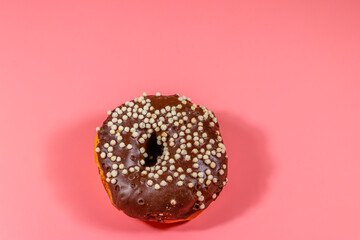 Tasty chocolate donut on a pink background