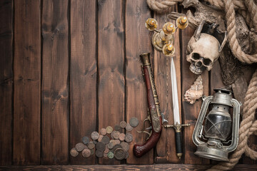 Pirate equipment on the brown wooden table concept background with copy space.